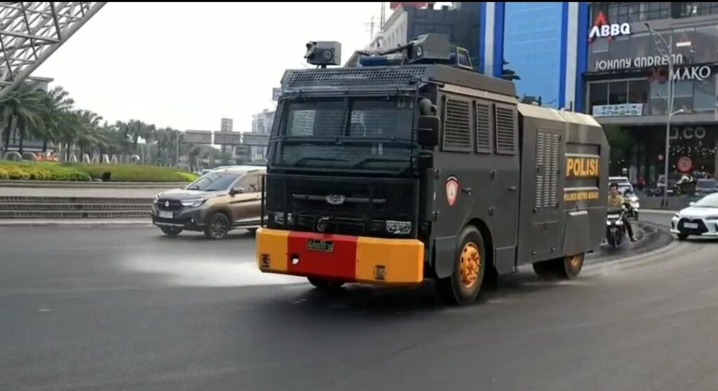 PENYEMPROTAN PEMBERSIHAN ABU VULKANIK MENGGUNAKAN WATER CANNON OLEH SATUAN SAMAPTA POLRES METRO BEKASI KOTA DI JALAN PROTOKOL KOTA BEKASI