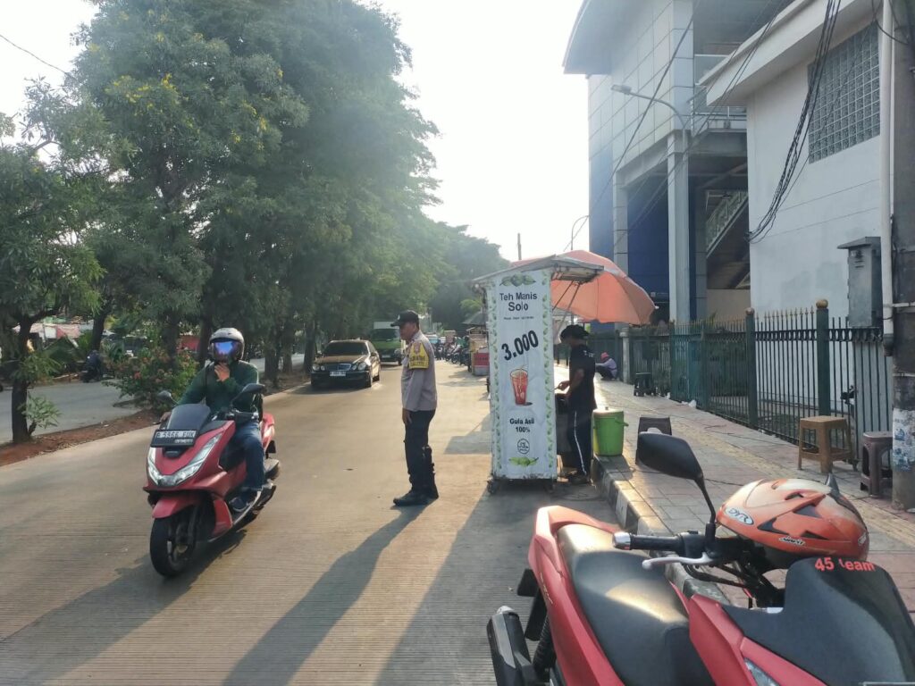 Senyum Hangat di Tengah Keriuhan Pasar Pagi, Polantas Setia Jalankan Tugas Urai Kemacetan Bintara